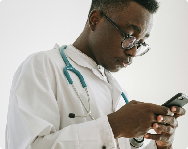 A doctor in a white coat using the FitHealth app on his phone